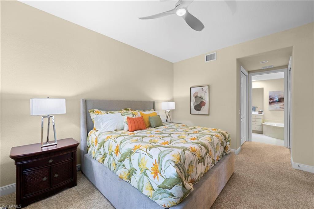 7837 Hawthorne Drive, Unit 1101 Naples, FL 34113 - Photo 10 of 41 a bedroom with a bed and a lamp