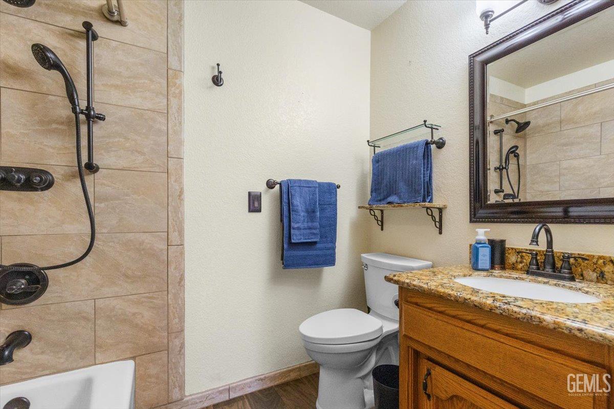 Undisclosed Address Tehachapi, CA 93561 - Photo 16 of 46 a bathroom with a granite countertop sink a toilet and shower