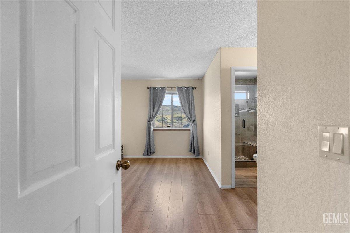 Undisclosed Address Tehachapi, CA 93561 - Photo 24 of 46 an empty room with wooden floor mirror and windows