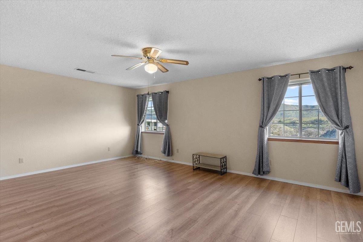 Undisclosed Address Tehachapi, CA 93561 - Photo 25 of 46 a view of empty room with wooden floor and fan