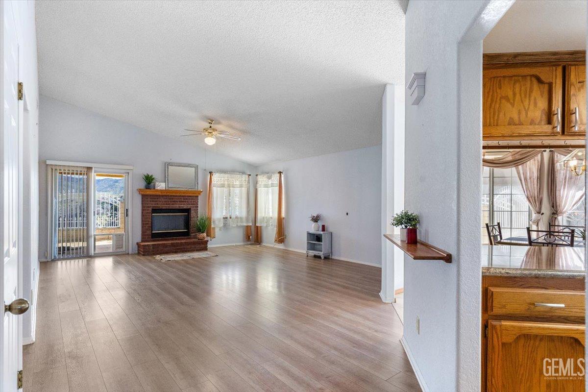Undisclosed Address Tehachapi, CA 93561 - Photo 5 of 46 a view of empty room with fireplace and wooden floor