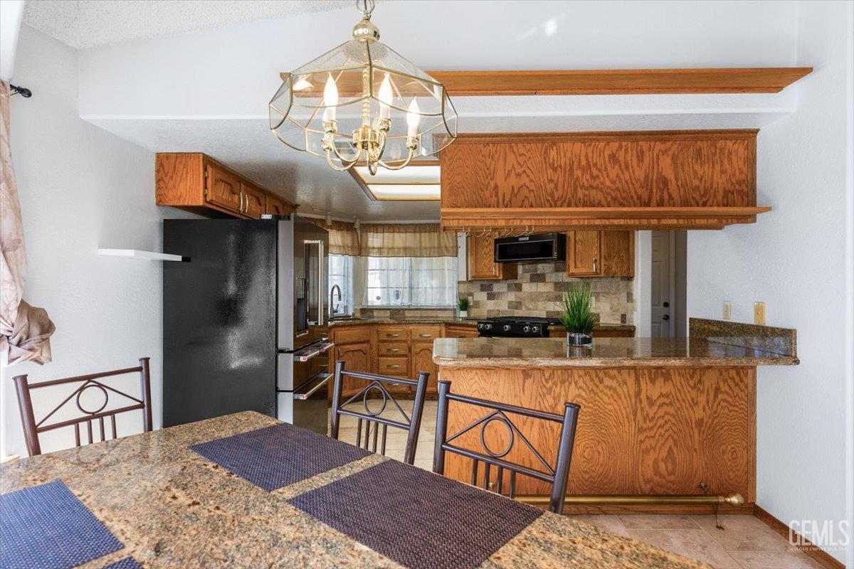 Undisclosed Address Tehachapi, CA 93561 - Photo 9 of 46 a dining room with wooden floor a chandelier a wooden table and chairs
