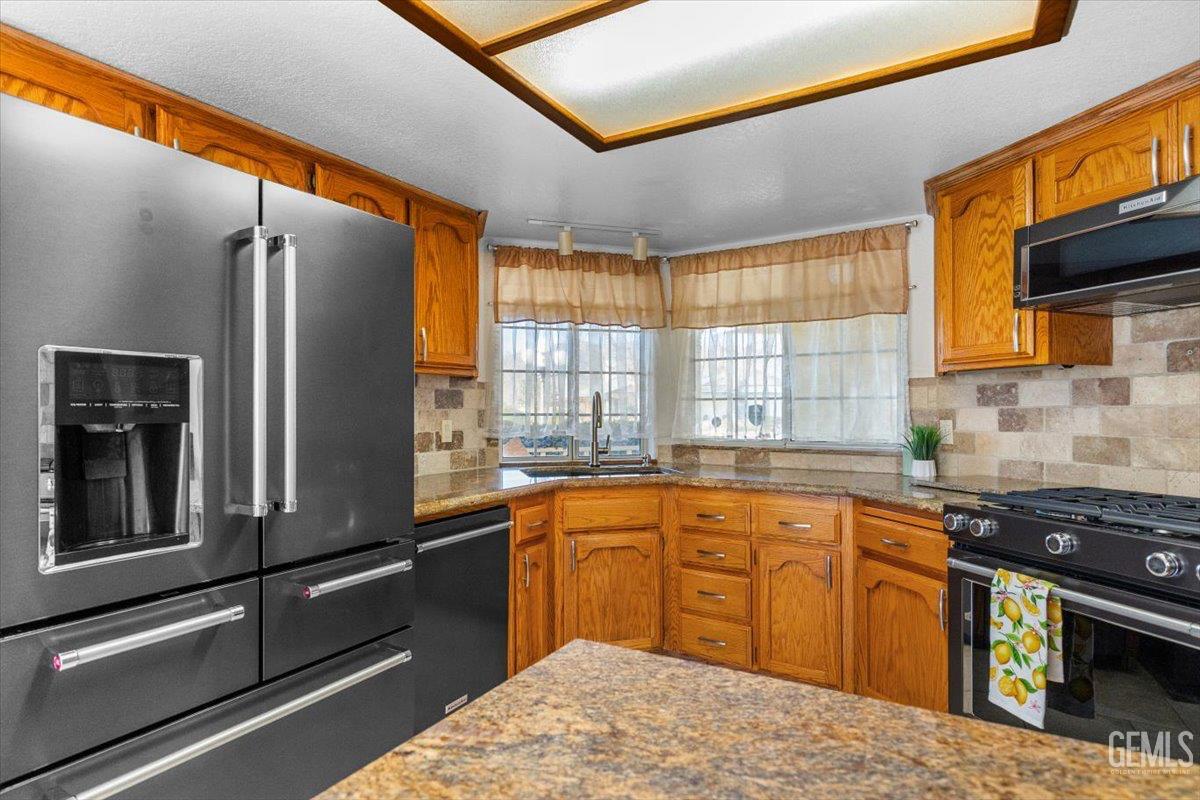 Undisclosed Address Tehachapi, CA 93561 - Photo 10 of 46 a kitchen with stainless steel appliances granite countertop a refrigerator a sink dishwasher a stove and white countertops with wooden floor