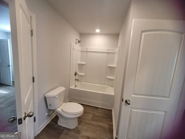 a bathroom with a toilet and a shower