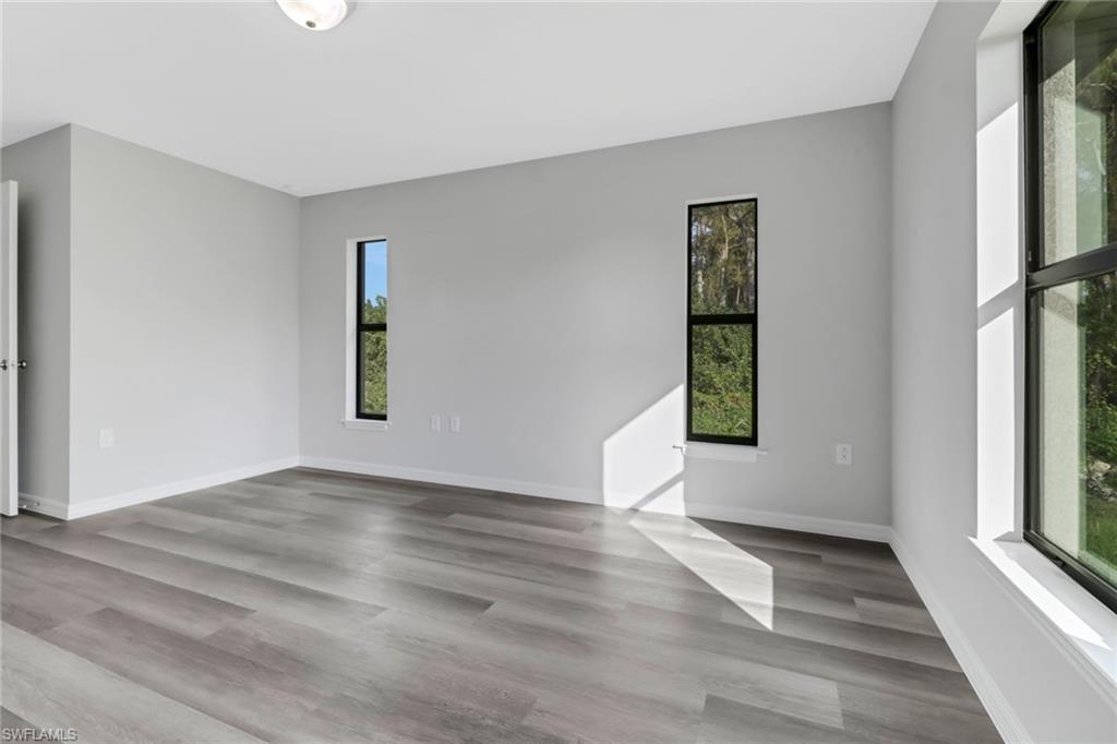 1012 Anza Avenue Lehigh Acres, FL 33971 - Photo 14 of 25 a view of an empty room with window and wooden floor