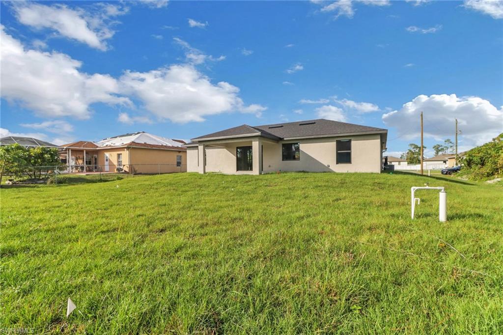 1012 Anza Avenue Lehigh Acres, FL 33971 - Photo 2 of 25 a house view with a garden space