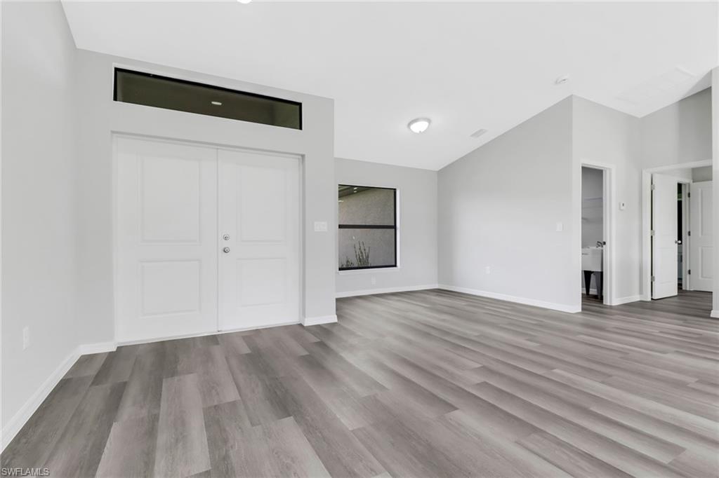1012 Anza Avenue Lehigh Acres, FL 33971 - Photo 3 of 25 a view of an empty room with wooden floor and window