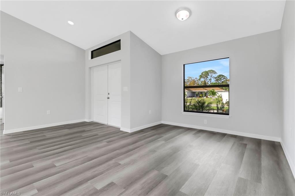 1012 Anza Avenue Lehigh Acres, FL 33971 - Photo 5 of 25 an empty room with wooden floor and window
