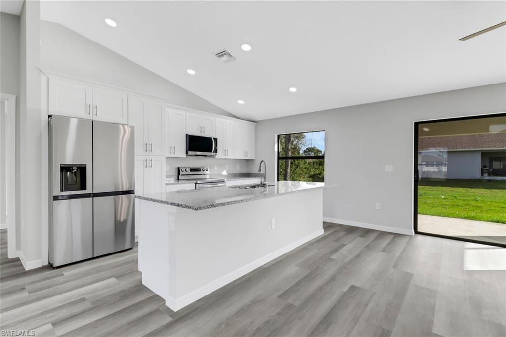 1012 Anza Avenue Lehigh Acres, FL 33971 - Photo 10 of 25 a kitchen with stainless steel appliances granite countertop a refrigerator stove top oven and sink