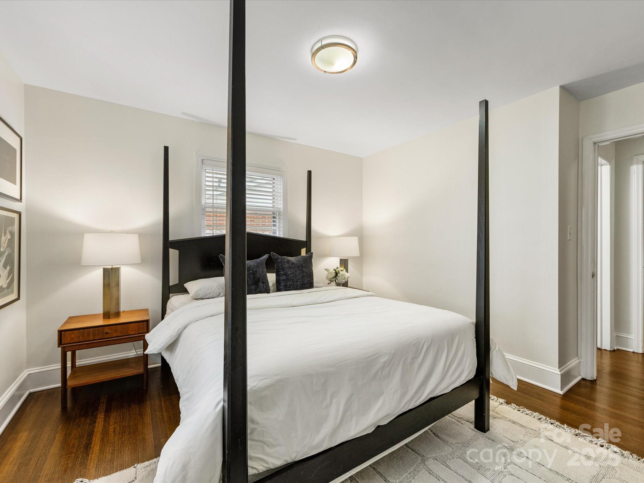 2908 Enfield Road Charlotte, NC 28205 - Photo 20 of 32 a bedroom with a bed and a lamp with wooden floor