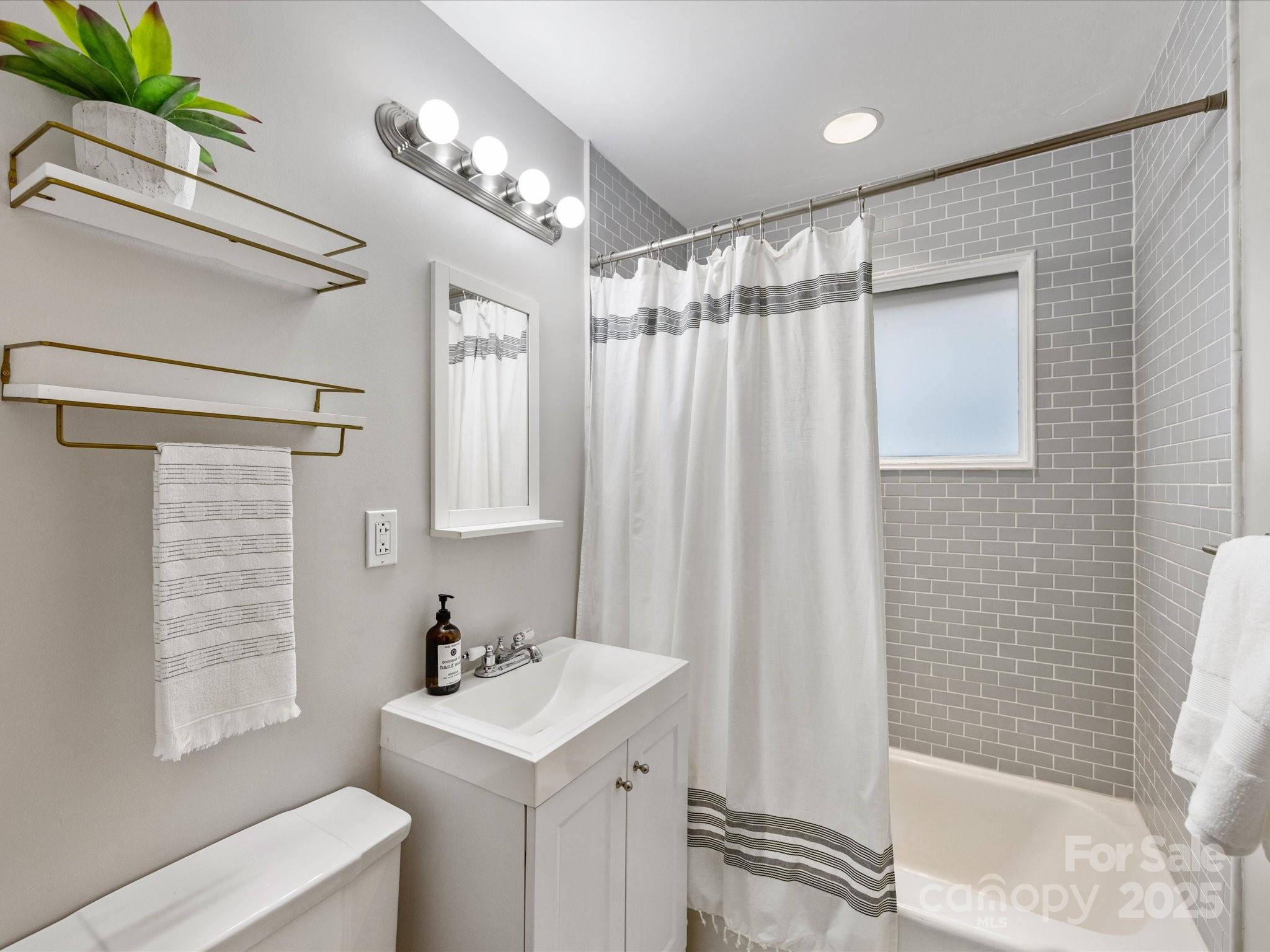 2908 Enfield Road Charlotte, NC 28205 - Photo 21 of 32 a bathroom with a sink a mirror and a shower