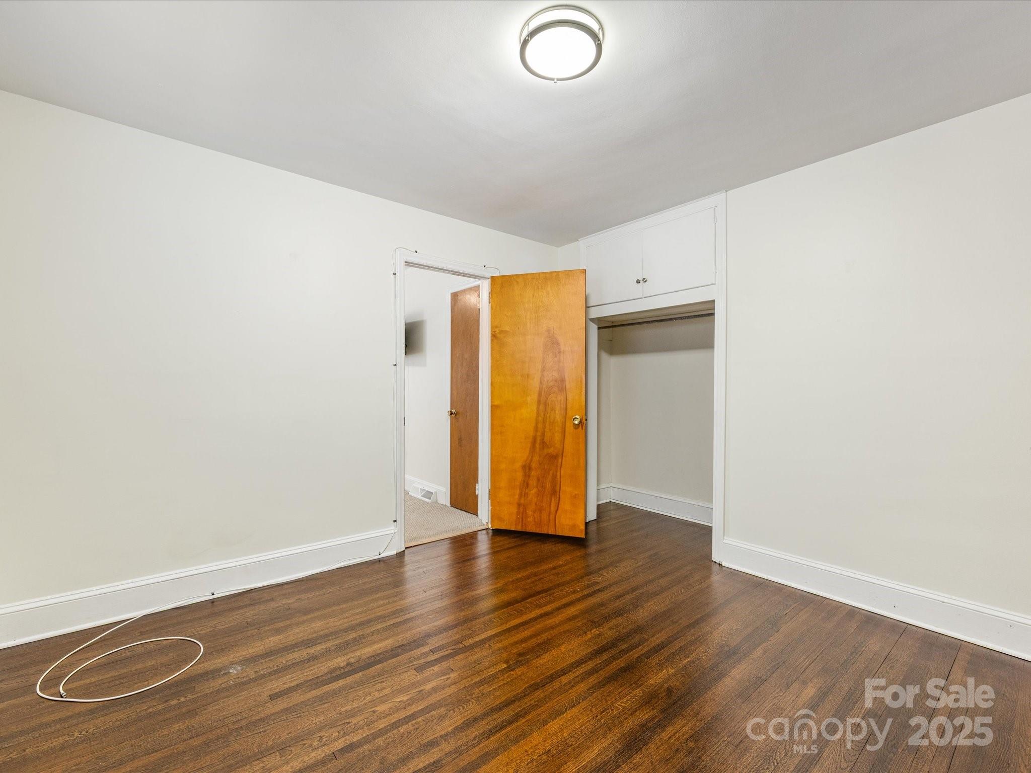 2908 Enfield Road Charlotte, NC 28205 - Photo 23 of 32 an empty room with wooden floor and closet