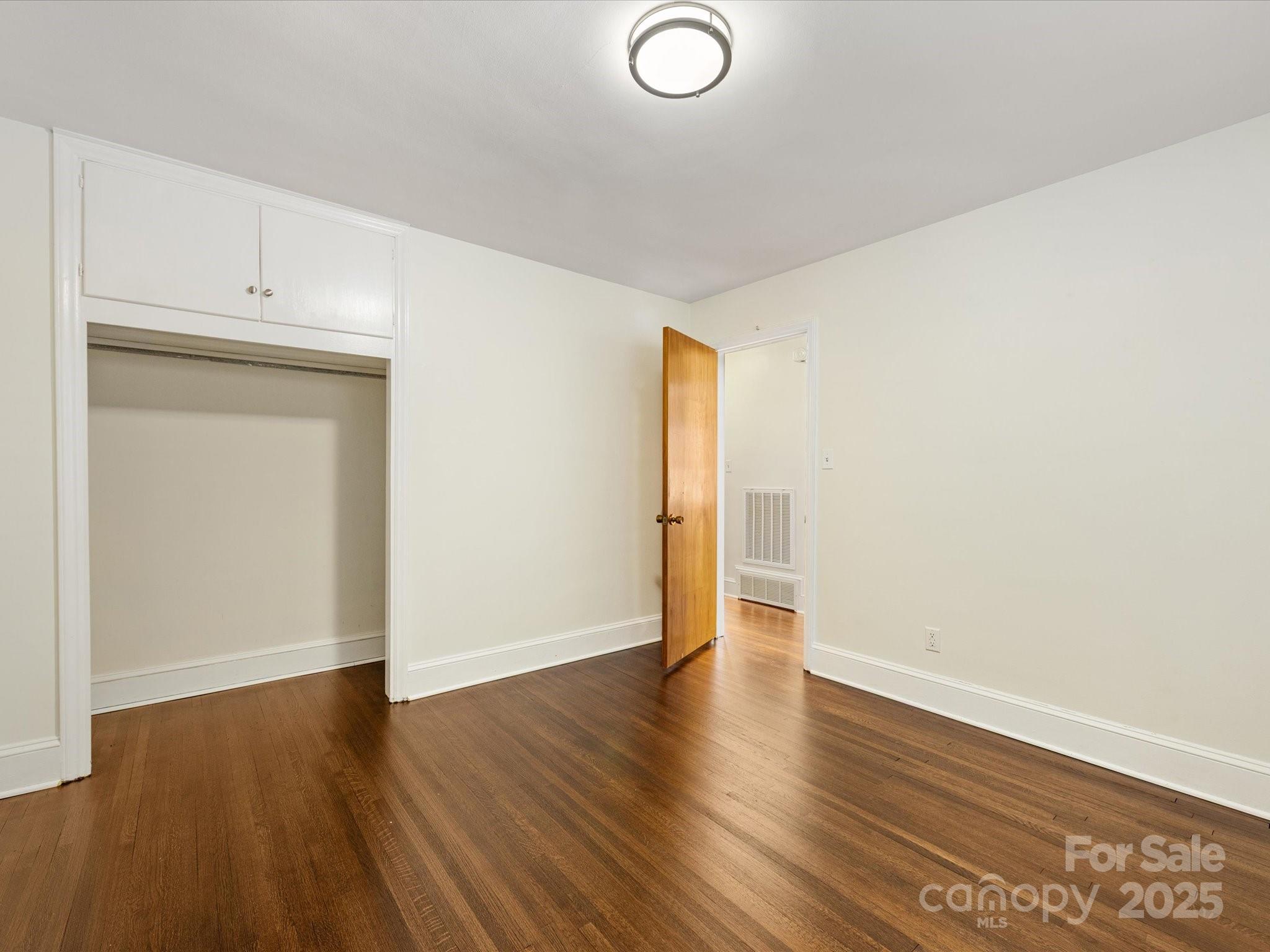 2908 Enfield Road Charlotte, NC 28205 - Photo 24 of 32 an empty room with wooden floor and closet