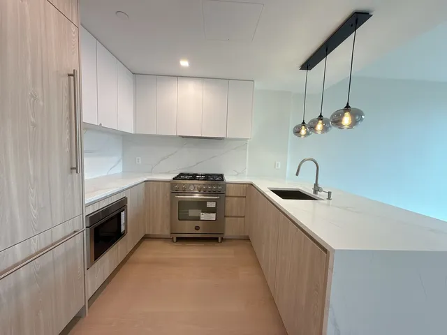 a kitchen with granite countertop a sink stainless steel appliances and cabinets