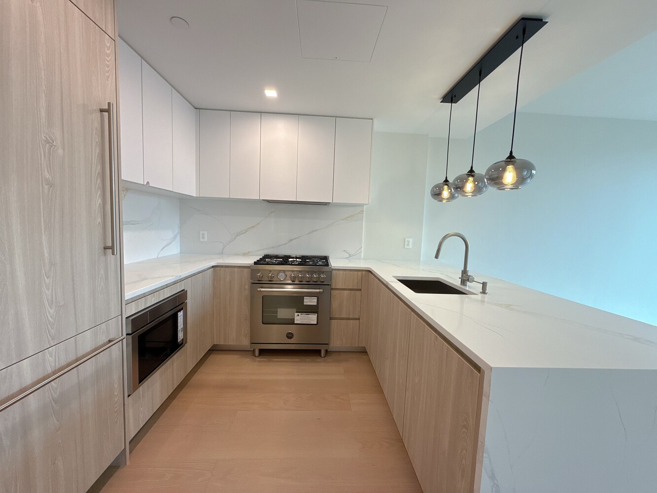 11-36 45th Road, Unit 403A Queens, NY 11101 - Photo 4 of 15 a kitchen with granite countertop a sink stainless steel appliances and cabinets