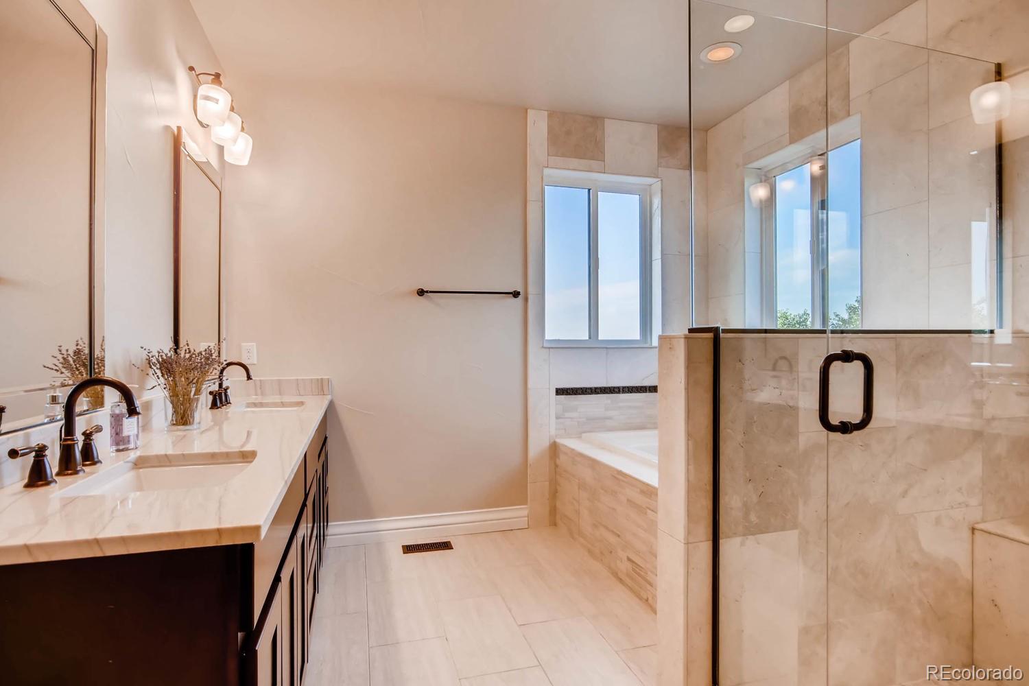 4880 Easley Road Golden, CO 80403 - Photo 14 of 40 a bathroom with a double vanity sink a mirror and a shower