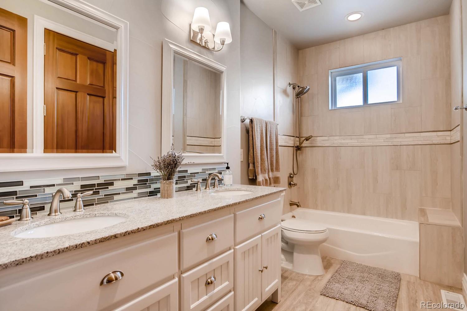 4880 Easley Road Golden, CO 80403 - Photo 16 of 40 a bathroom with a granite countertop sink a toilet and a bathtub