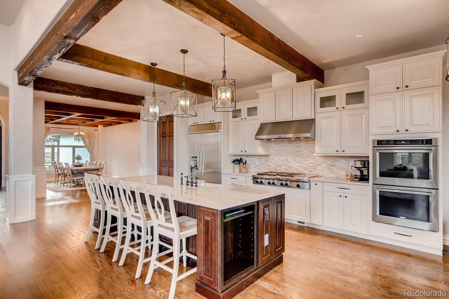 4880 Easley Road Golden, CO 80403 - Photo 6 of 40 a kitchen with stainless steel appliances granite countertop a stove top oven a sink a dining table and chairs with wooden floor
