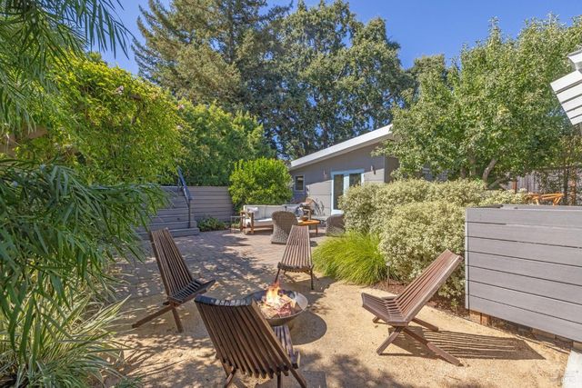 a view of backyard with outdoor seating and plants