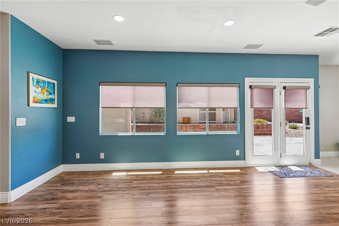 1176 Butternut Ranch Court Henderson, NV 89052 - Photo 7 of 60 Luminous living space featuring durable hardwood flooring and a convenient outdoor connection.