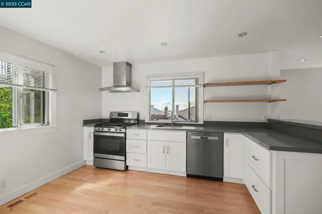 a kitchen with granite countertop white cabinets and white appliances