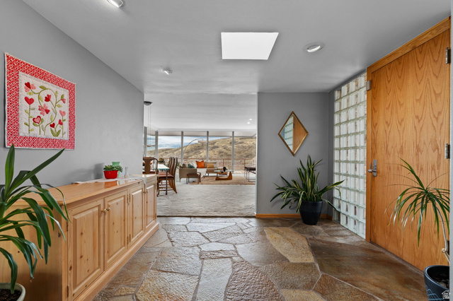 1856 Fort Canyon Road Alpine, UT 84004 - Photo 4 of 49 Entryway featuring flagstone flooring, a natural wood entry door, and a glass block privacy wall