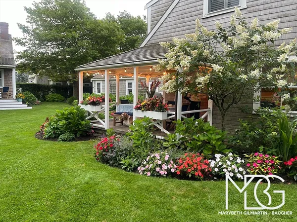 a view of a house with a backyard and sitting area
