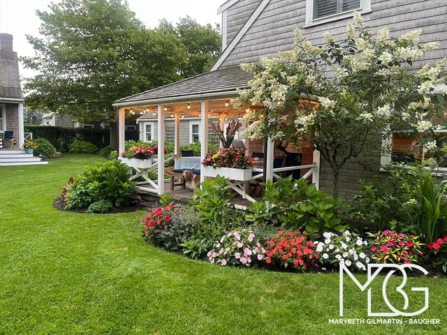 a view of a house with a backyard and sitting area