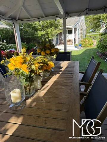 a view of a chairs and table in backyard of a house