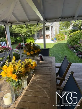 a view of a patio with table and chairs potted plants and a palm tree