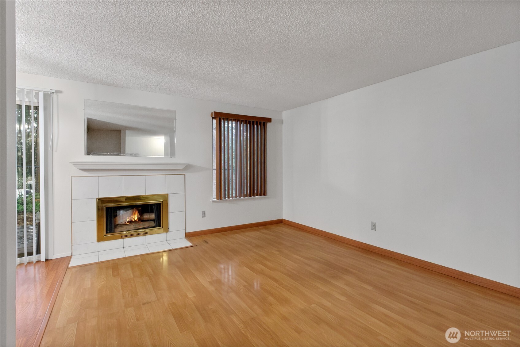127 South 340th Street, Unit A Federal Way, WA 98003 - Photo 8 of 19 a view of empty room with wooden floor and fireplace