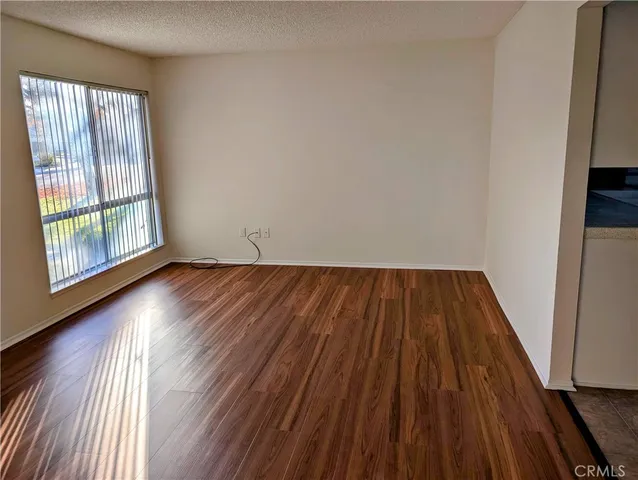 a view of a room with wooden floor and ceiling fan