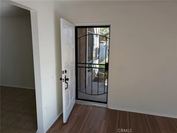 an empty room with wooden floor closet and windows