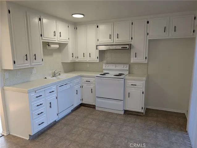 a kitchen with cabinets stainless steel appliances and a counter space
