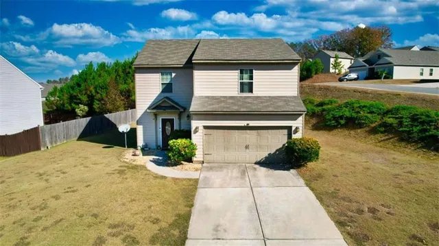 a front view of a house with a yard and garage