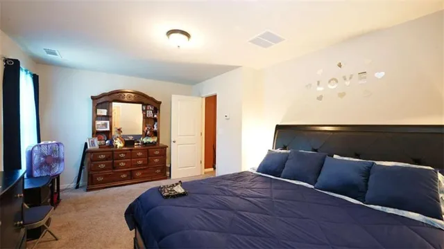 a bedroom with a bed and dresser with mirror