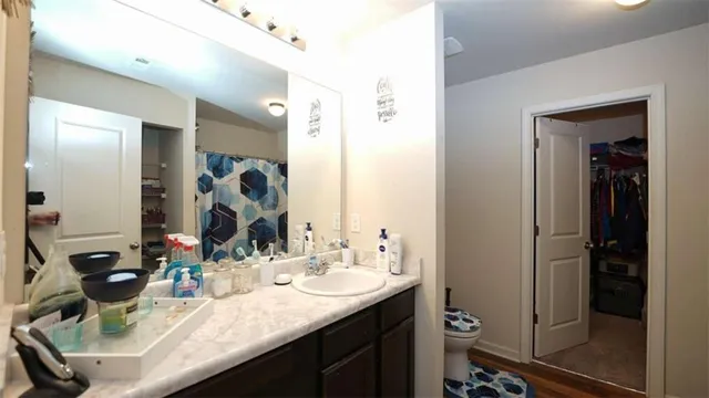a bathroom with a granite countertop sink a mirror and a shower