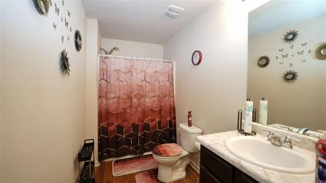 a bathroom with a sink mirror vanity and toilet