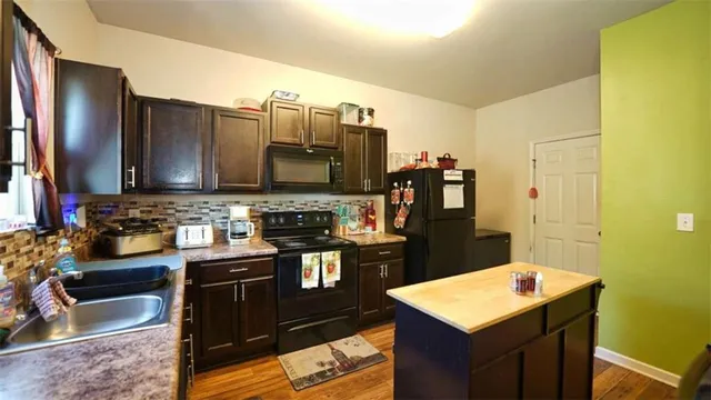 a kitchen with stainless steel appliances kitchen island granite countertop a refrigerator stove and sink