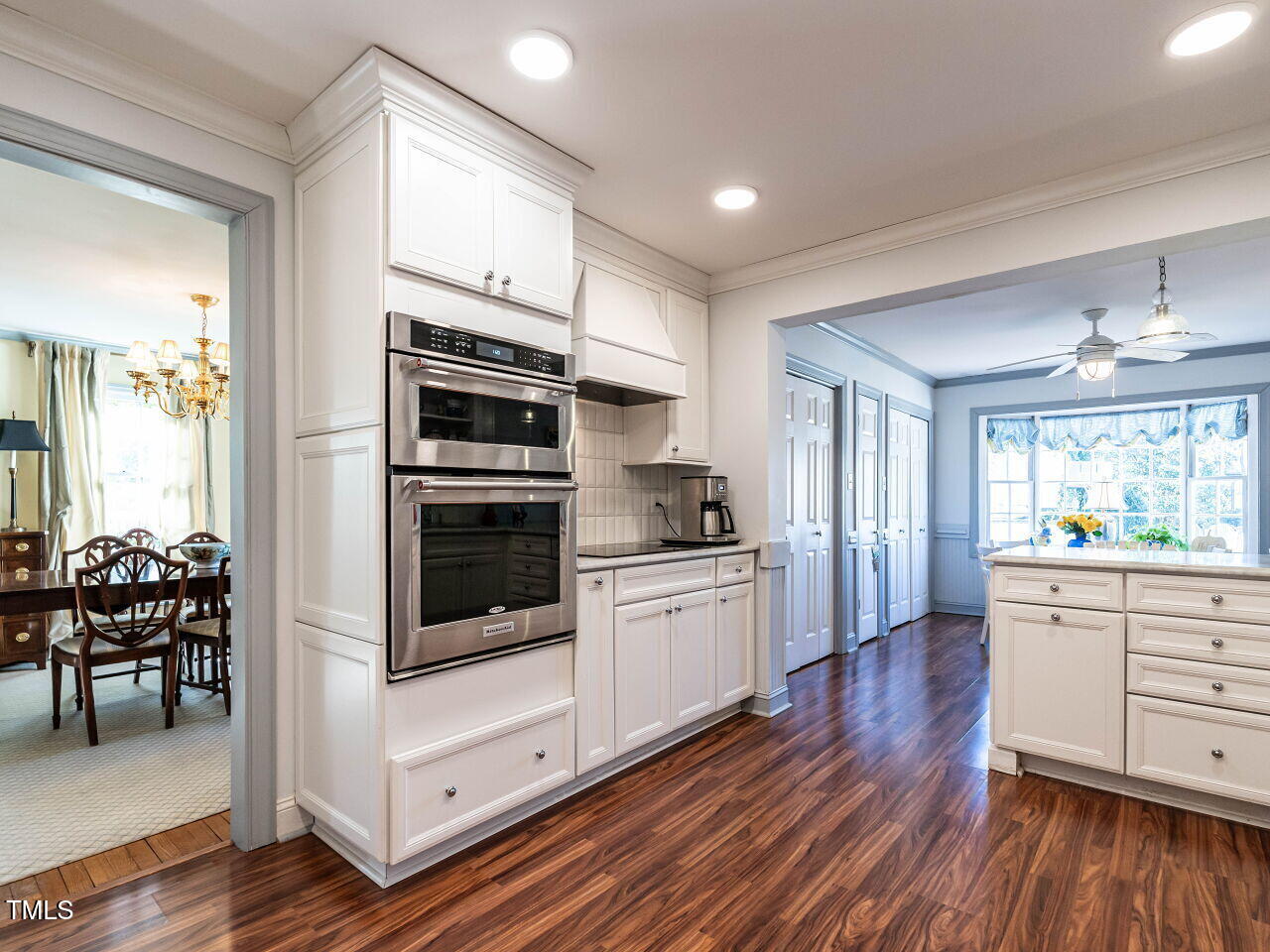 2521 St Marys Street Raleigh, NC 27609 - Photo 10 of 29 a kitchen with stainless steel appliances a stove a sink and white cabinets with wooden floor