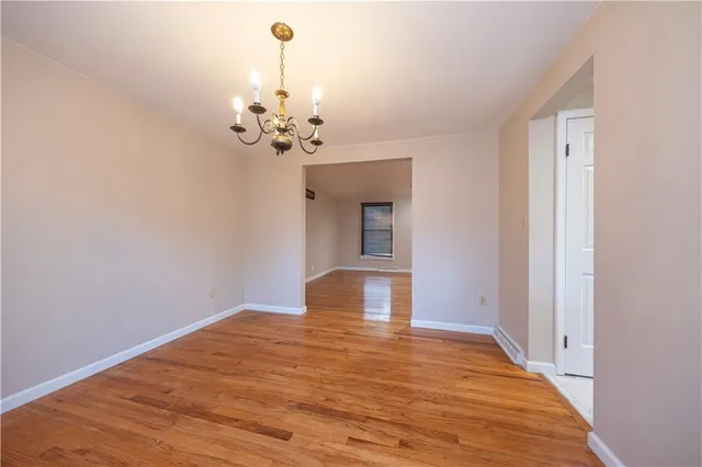 a view of a room with wooden floor and chandelier