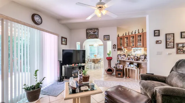 a living room with furniture a chandelier and a flat screen tv