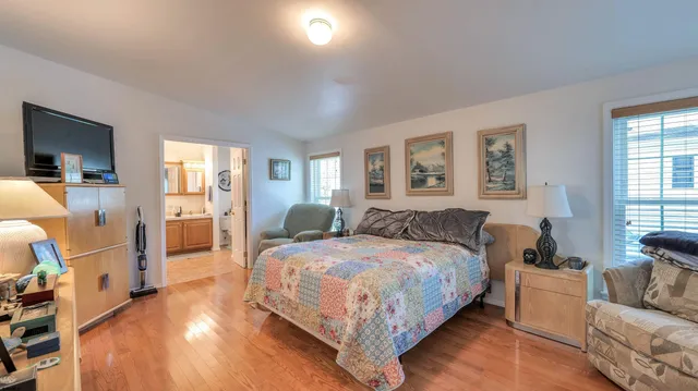 a spacious bedroom with a bed and wooden floor