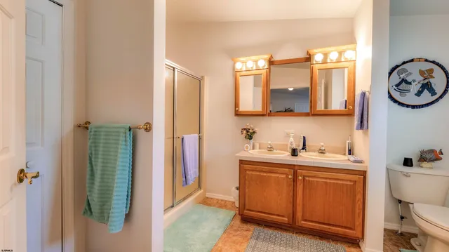 a bathroom with a two sinks a mirror and a window
