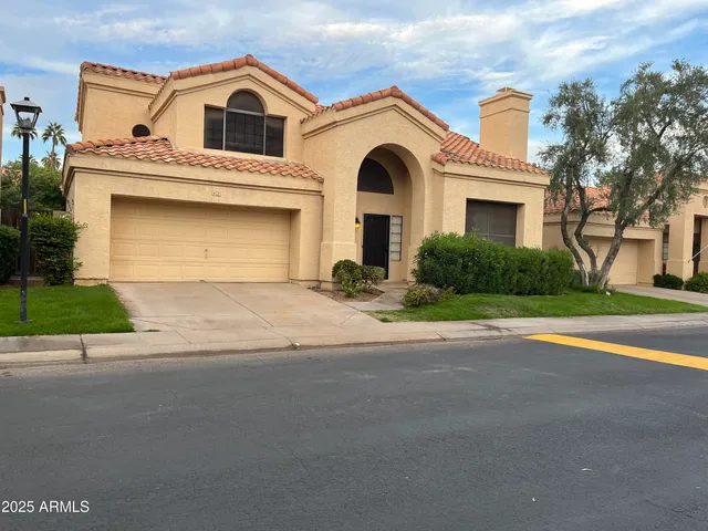 a view of a white house with a yard and plants