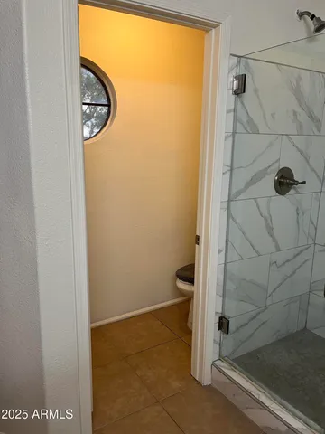 an empty room with wooden floor and mirror