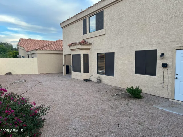 a view of a house with a large window and wooden fence