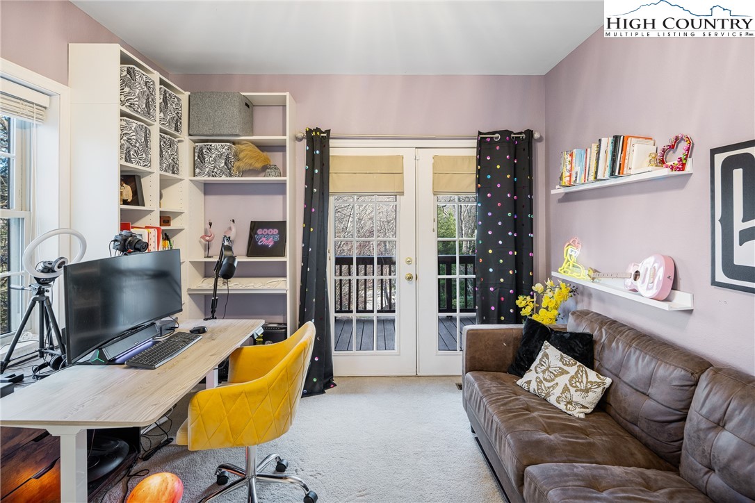 144 Grandfather Farms Road Banner Elk, NC 28604 - Photo 28 of 41 a living room with furniture a flat screen tv and a floor to ceiling window