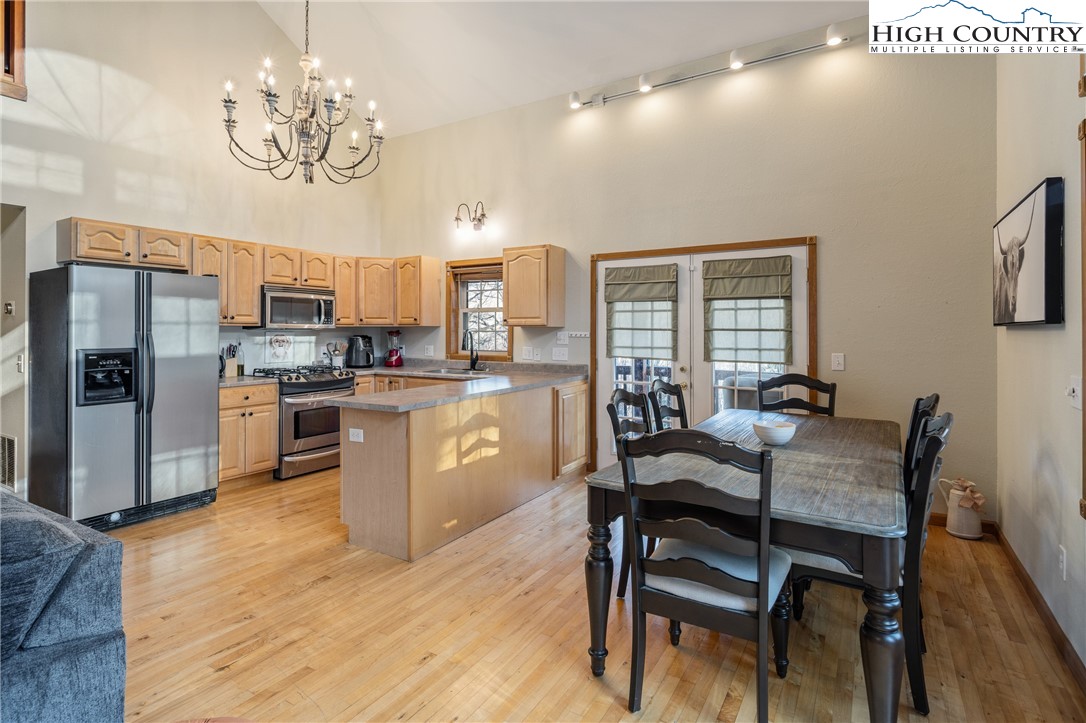 144 Grandfather Farms Road Banner Elk, NC 28604 - Photo 4 of 41 a kitchen with stainless steel appliances granite countertop a stove a refrigerator a kitchen island a dining table and chairs with wooden floor
