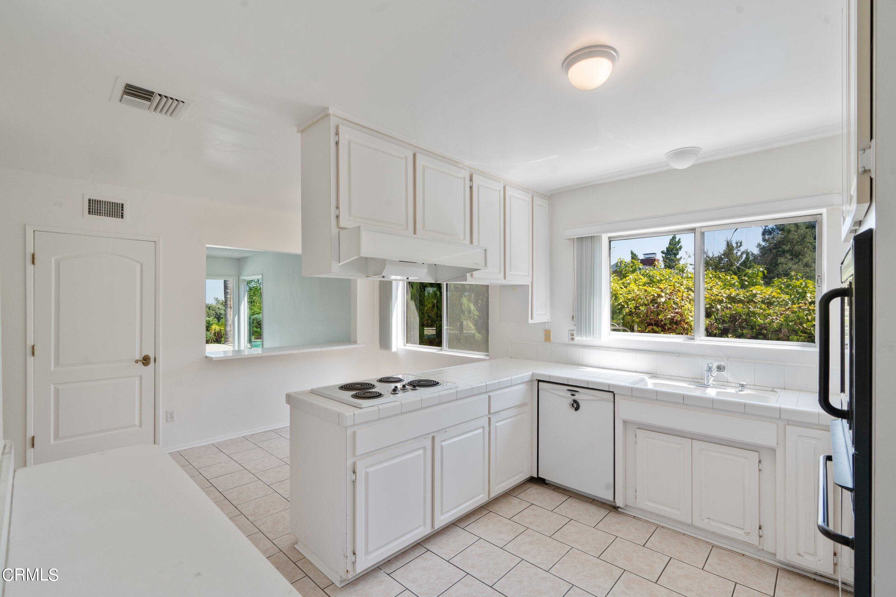 3347 Wrightwood Drive Studio City, CA 91604 - Photo 28 of 44 a kitchen with white cabinets a sink a stove and a window